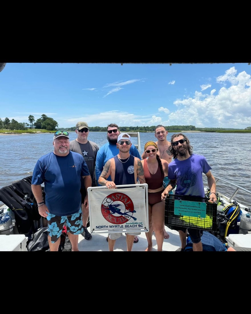 The Carolina Reef Foundation dive crew on the boat with the foundation banner